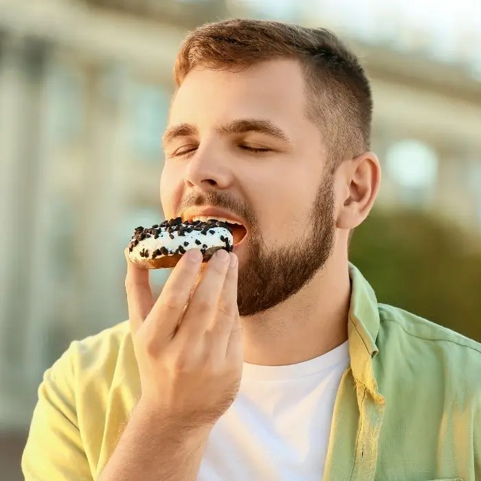 Man eating a sugary treat not being mindful of his teeth health