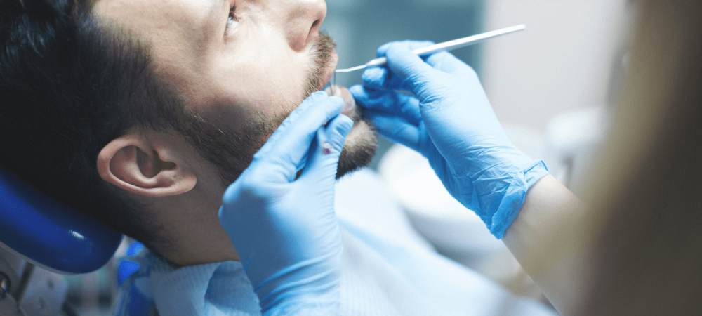 Young man getting his teeth examined by Dr. Byrne