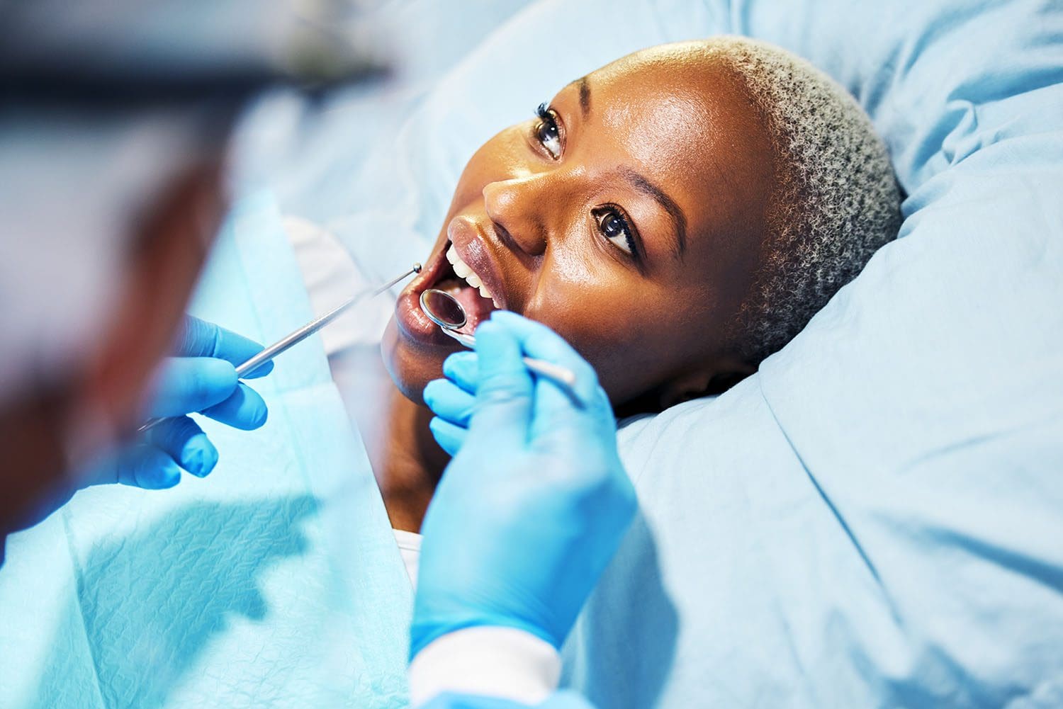 Woman in dental chair while Dr. Byrne inspects upper row of teeth