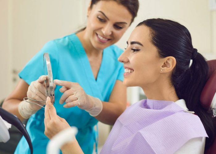 Woman looking at teeth after receiving a root canal Woman looking at teeth after receiving a root canal