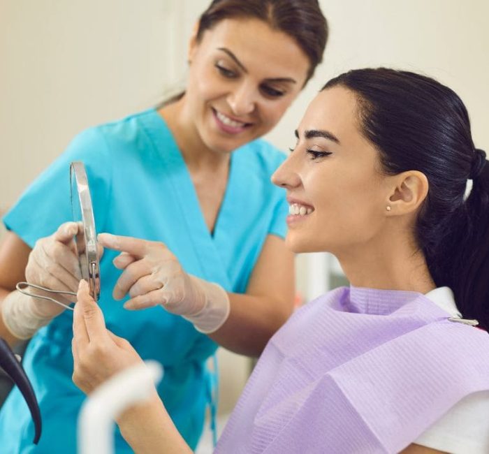 Woman looking at teeth after receiving a root canal Woman looking at teeth after receiving a root canal