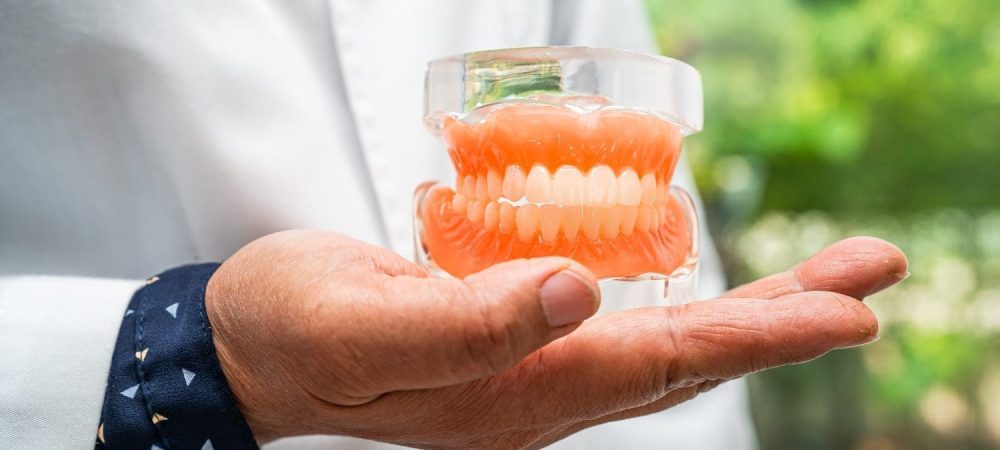 Hand holding dentures